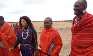 Mindy Budgor standing with a group of warriors in Maasai land