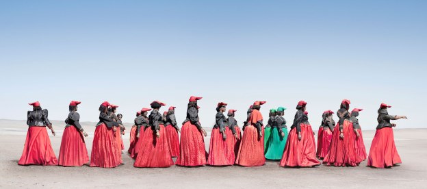 A photo graph of modern-day Herero women. Herero women marching. In 2011 Jim Naughten spent four months photographing the Herero tribe of Namibia. The London-based photographer drove thousands of miles through the desert, meeting and negotiating with people, camping and continuously cleaning the dust out of his camera equipment. Photo: Jim Naughten